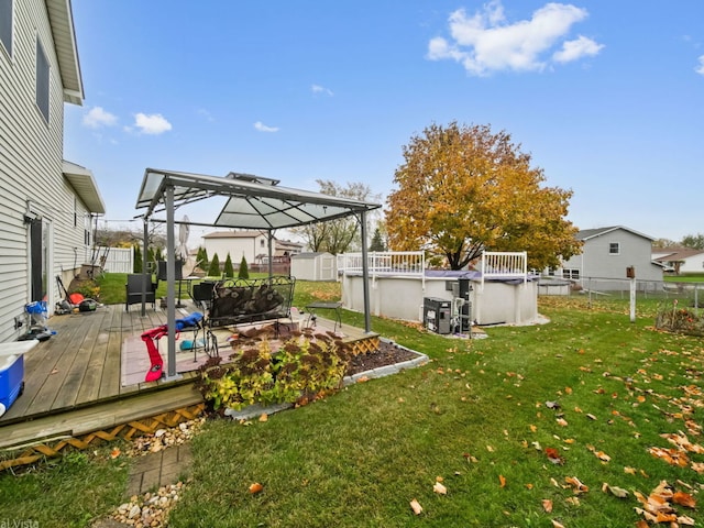 view of yard featuring a gazebo, a swimming pool side deck, and a shed