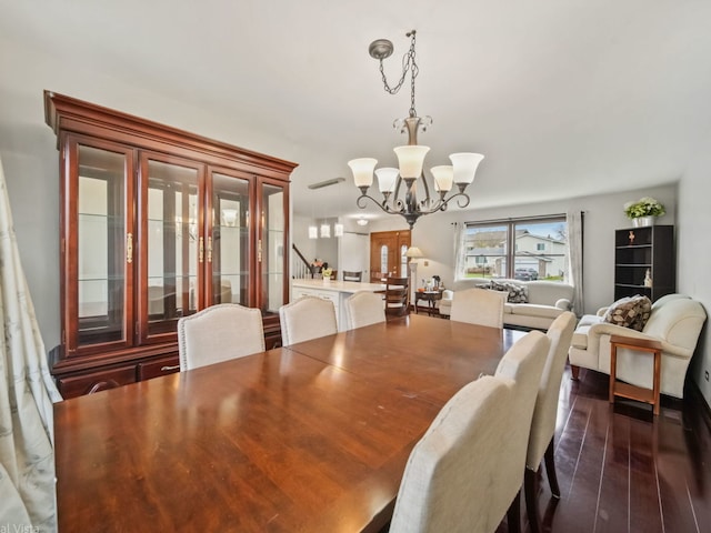 dining space with dark hardwood / wood-style flooring and a chandelier