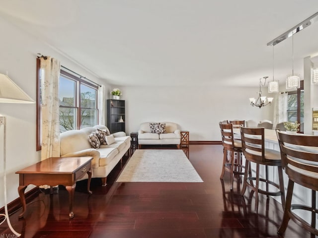 living room with dark wood-type flooring and a chandelier