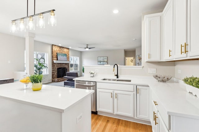 kitchen with a center island, dishwasher, sink, and white cabinets