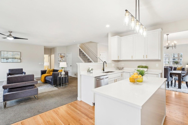 kitchen with white cabinetry, sink, decorative light fixtures, and stainless steel dishwasher