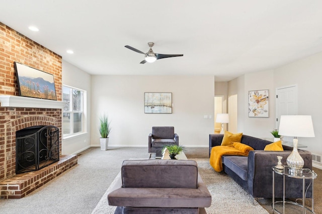 living room with a brick fireplace, light carpet, and ceiling fan