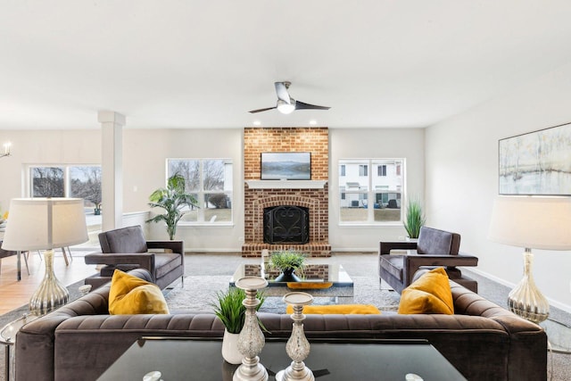 living room featuring ceiling fan, a fireplace, carpet floors, and a wealth of natural light