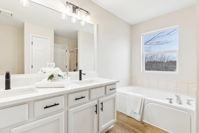 bathroom featuring vanity, hardwood / wood-style floors, and separate shower and tub