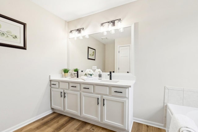 bathroom featuring vanity, hardwood / wood-style floors, and a washtub