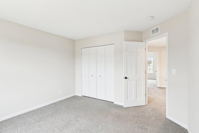 unfurnished bedroom featuring carpet flooring and a closet