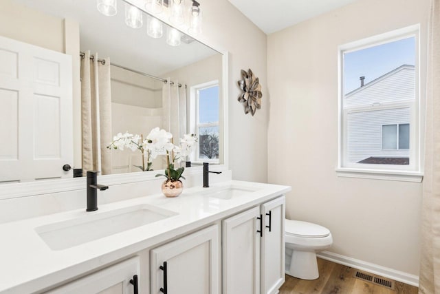 bathroom with vanity, toilet, curtained shower, and hardwood / wood-style floors