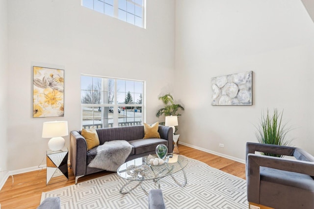 living room featuring a high ceiling and light hardwood / wood-style floors