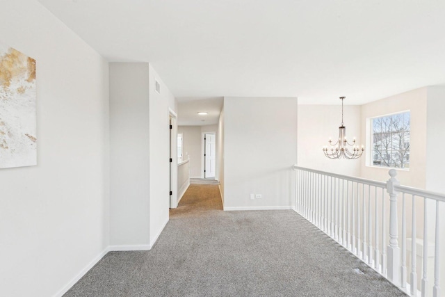 corridor featuring carpet flooring and an inviting chandelier