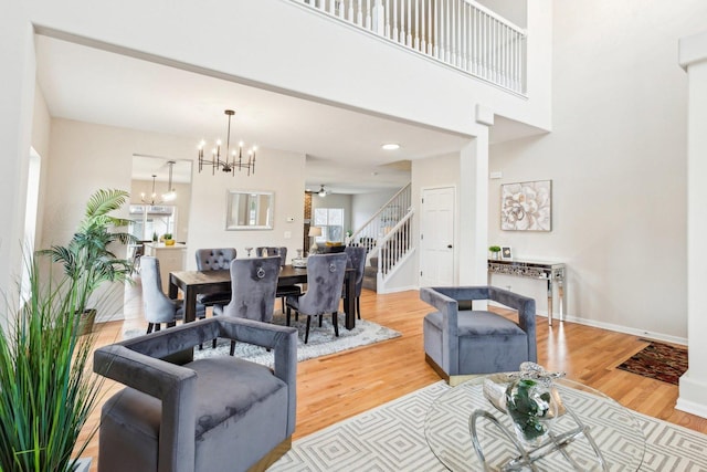 living room featuring a towering ceiling, hardwood / wood-style floors, and a notable chandelier