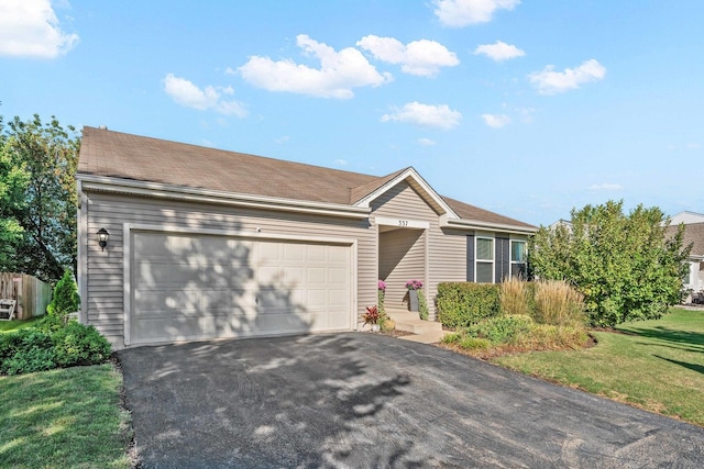 ranch-style home with a garage and a front lawn