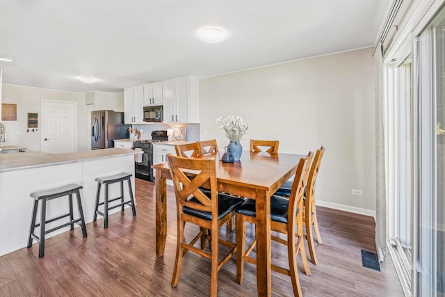 dining space with sink and light hardwood / wood-style floors