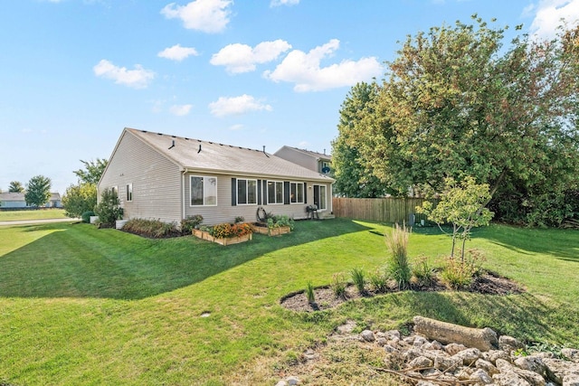 rear view of property featuring a lawn