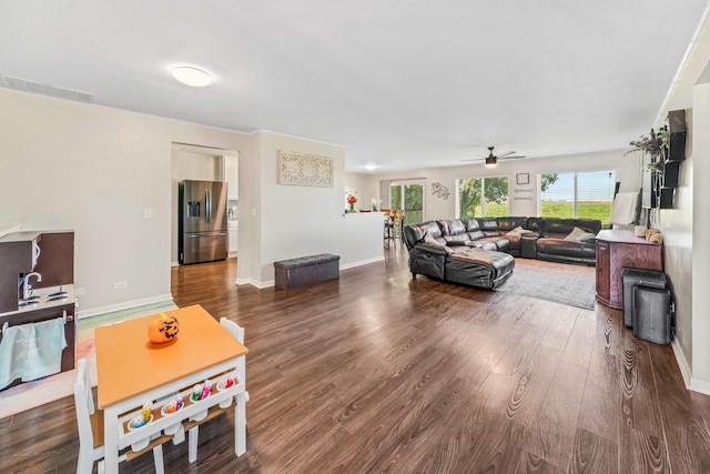 living room with ceiling fan and dark hardwood / wood-style flooring