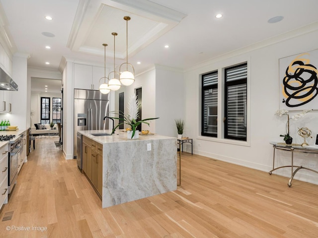 kitchen featuring stainless steel appliances, pendant lighting, white cabinets, and a spacious island