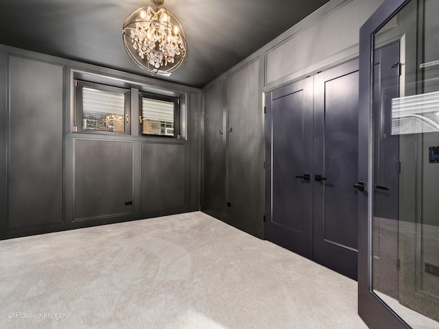 spare room with light carpet and a chandelier