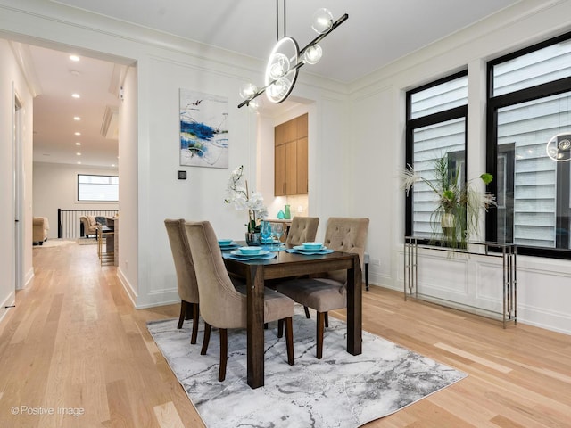 dining area with crown molding and light wood-type flooring