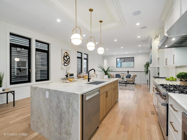 kitchen featuring stainless steel appliances, sink, white cabinets, and wall chimney exhaust hood