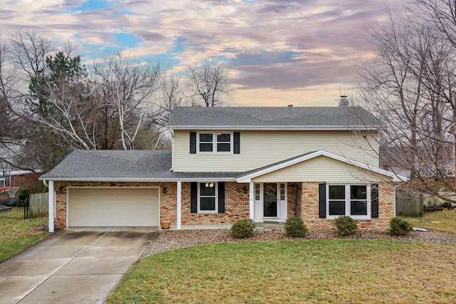 view of property featuring a garage and a lawn