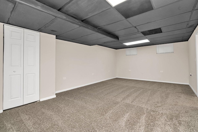 basement featuring carpet and a drop ceiling