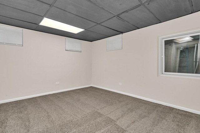 basement featuring carpet floors and a paneled ceiling