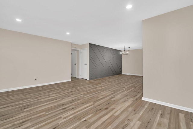 unfurnished living room featuring light wood-type flooring and a chandelier