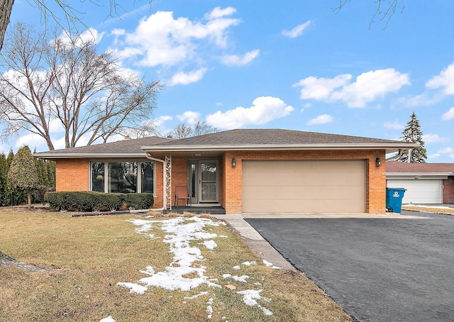 single story home with aphalt driveway, brick siding, a garage, and a front lawn