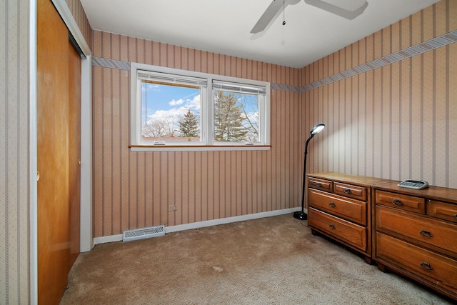 bedroom featuring light colored carpet, visible vents, baseboards, a closet, and wallpapered walls