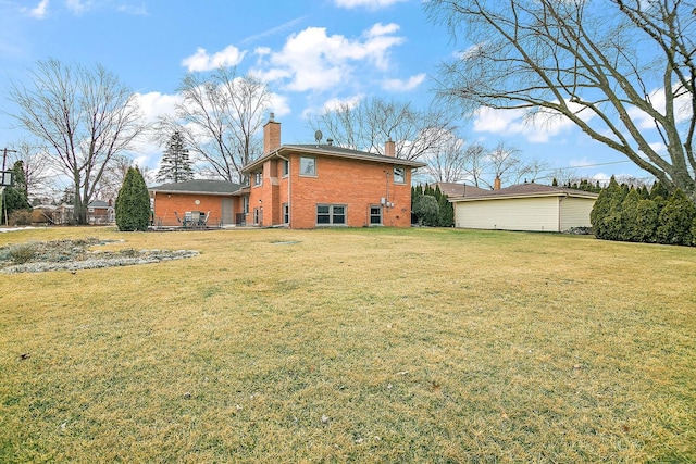 back of house with a chimney, a lawn, and brick siding