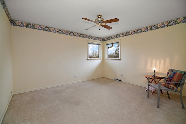 unfurnished room featuring ceiling fan, visible vents, baseboards, and light colored carpet