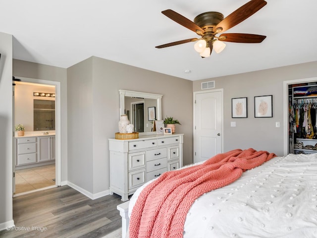 bedroom featuring connected bathroom, light hardwood / wood-style floors, a closet, and ceiling fan