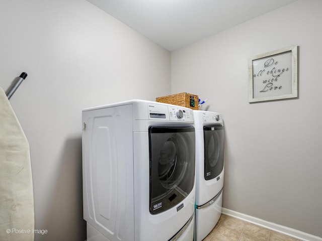 laundry room with washer and clothes dryer and light tile patterned floors