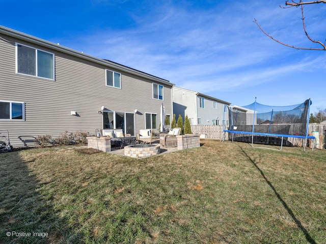 back of house with a yard, a trampoline, and a patio area