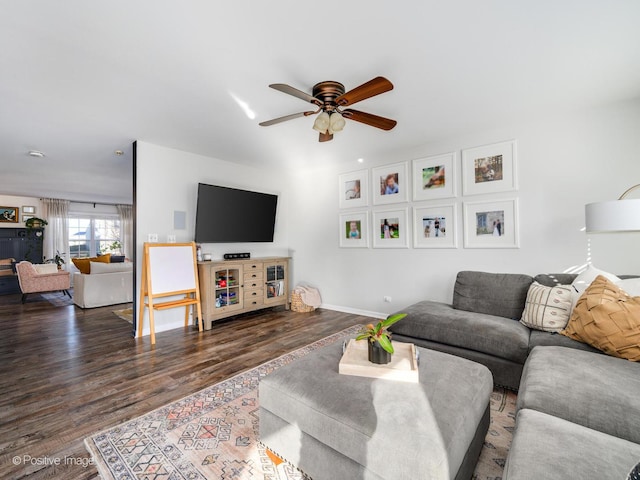 living room featuring dark wood-type flooring and ceiling fan