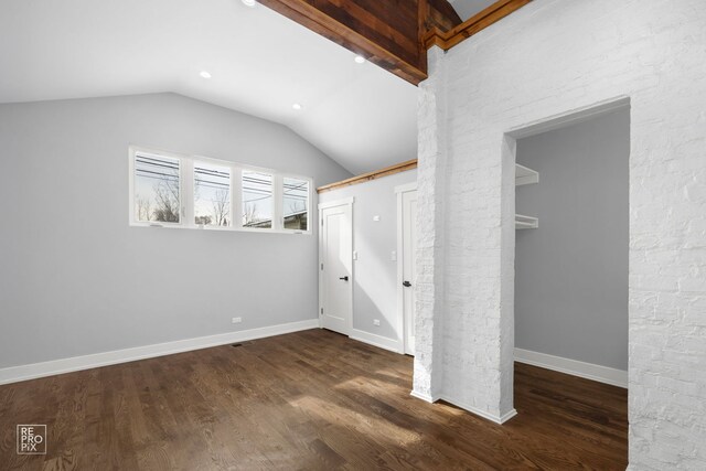 unfurnished bedroom featuring dark wood-style flooring, vaulted ceiling with beams, and baseboards