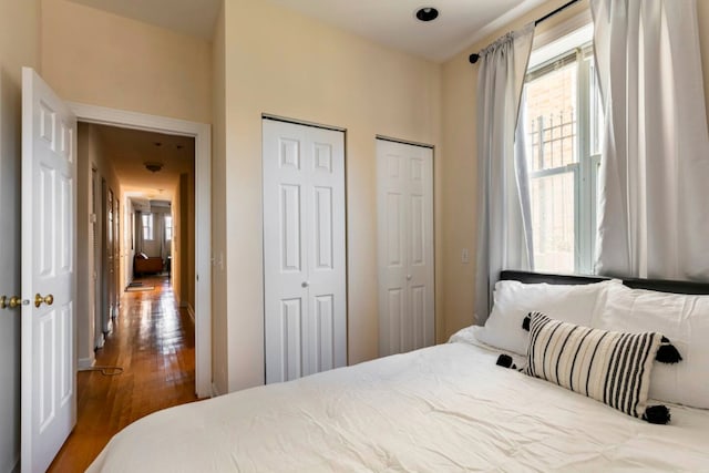 bedroom featuring hardwood / wood-style floors and two closets