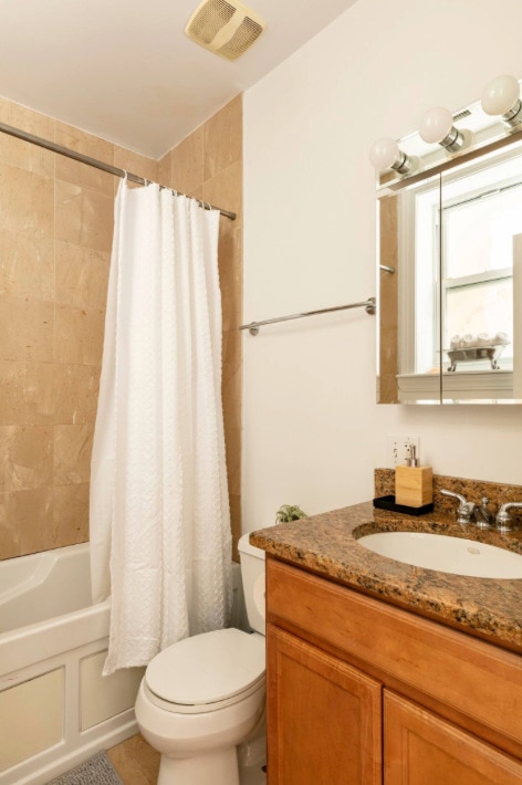 full bathroom featuring tile patterned flooring, vanity, shower / tub combo, and toilet