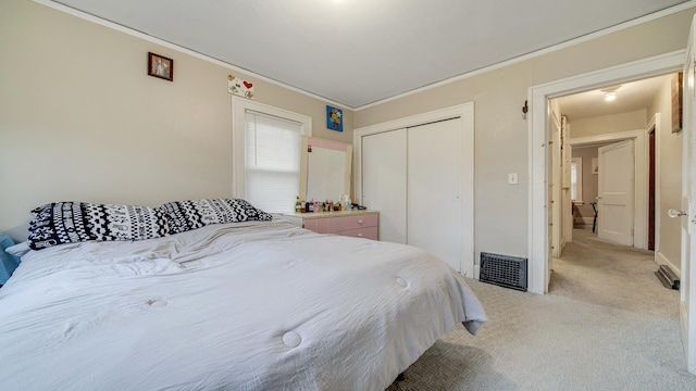 bedroom featuring crown molding, light colored carpet, and a closet