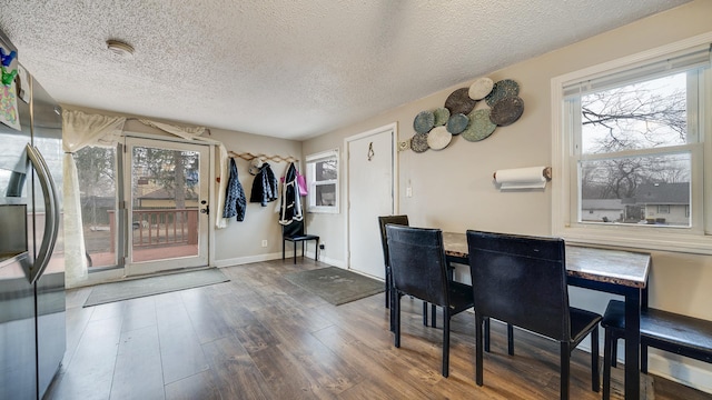 dining area featuring dark wood-type flooring and a textured ceiling