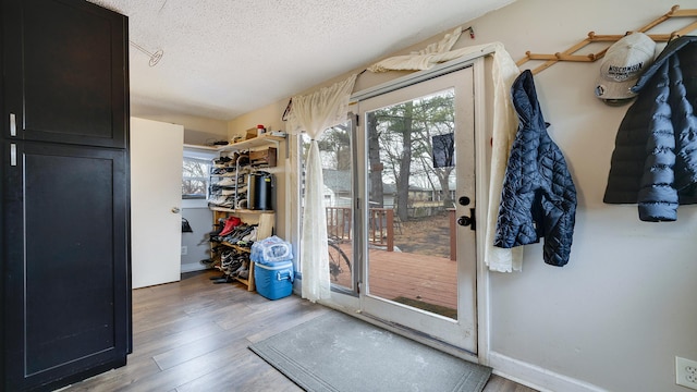 doorway with a textured ceiling and light wood-type flooring