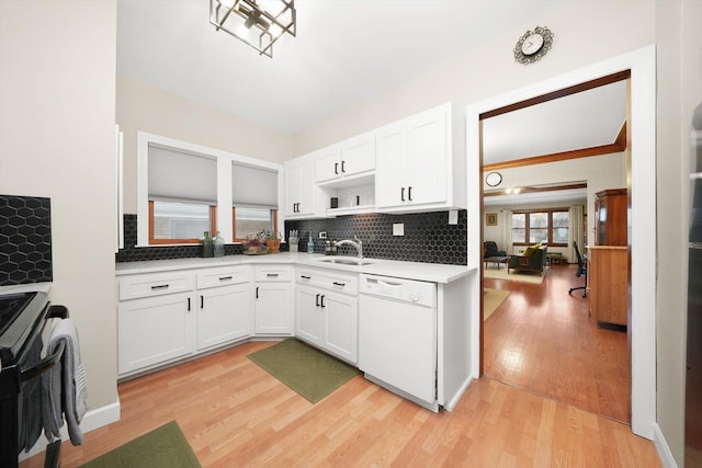 kitchen featuring white dishwasher, sink, white cabinetry, and decorative backsplash