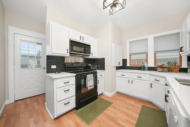 kitchen with white cabinetry, tasteful backsplash, black appliances, and light wood-type flooring