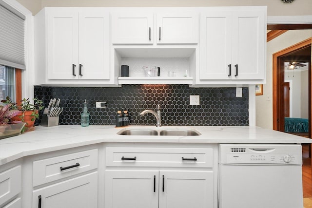 kitchen featuring sink, light stone counters, white cabinets, and white dishwasher