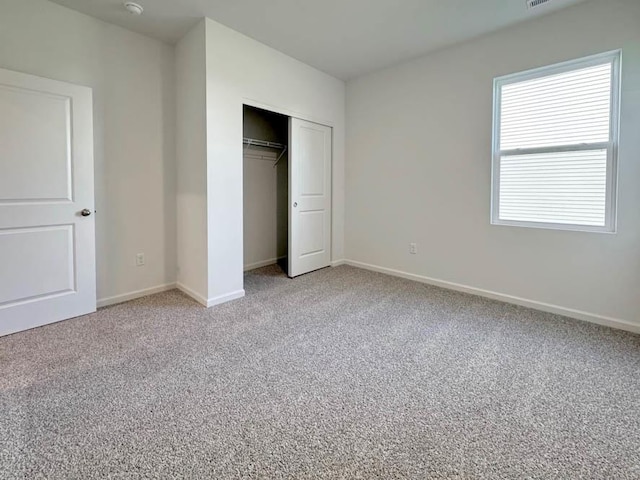 unfurnished bedroom with carpet flooring and a closet