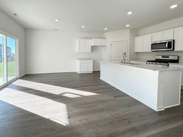 kitchen featuring sink, dark hardwood / wood-style flooring, stainless steel appliances, a kitchen island with sink, and white cabinets