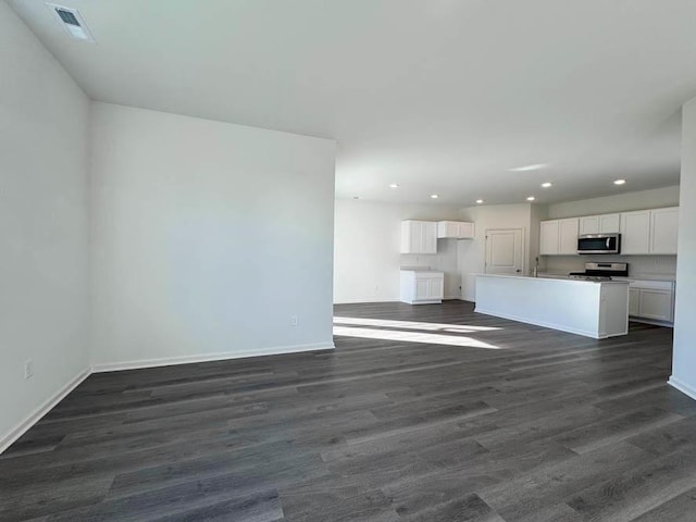 unfurnished living room with dark hardwood / wood-style flooring and sink