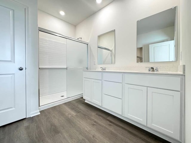 bathroom featuring an enclosed shower, vanity, and wood-type flooring