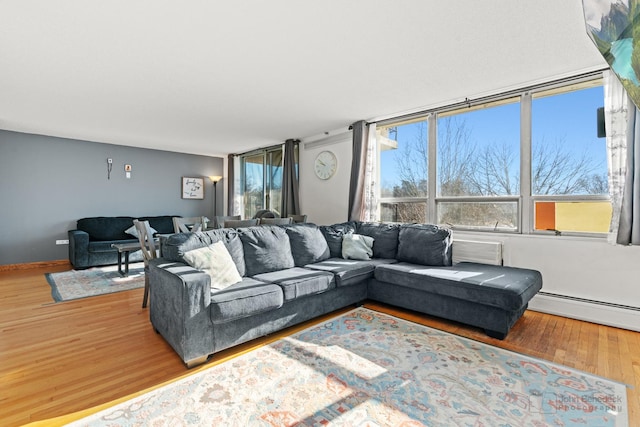 living room with a baseboard heating unit and hardwood / wood-style flooring