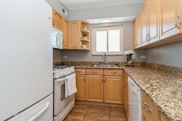 kitchen with light tile patterned flooring, white appliances, light brown cabinetry, and sink