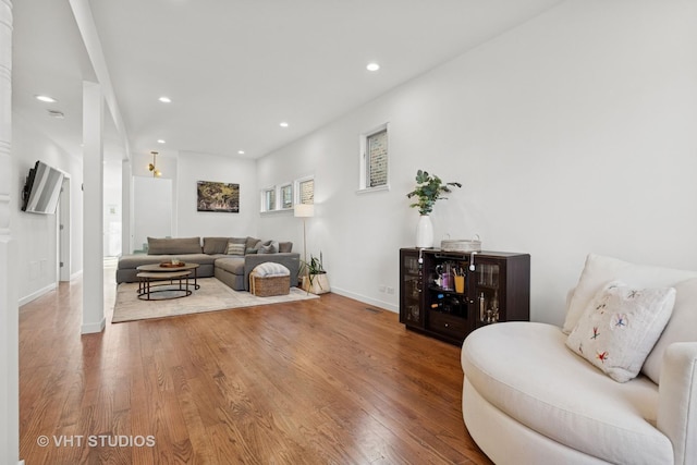 living area featuring wood-type flooring, baseboards, and recessed lighting